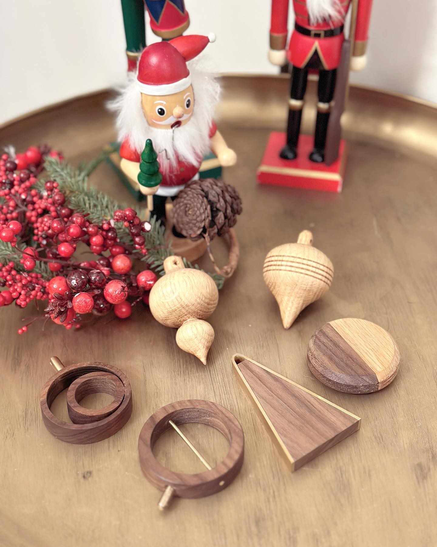 The ornaments laid out on a wooden tray beside a red berry wreath and painted nutcrackers