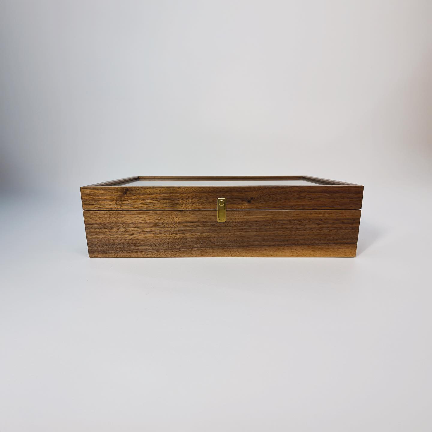 The box closed and seen straight on, the brass clasp centred on the case front