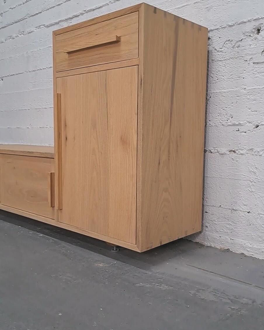 Close view of the tall cabinet, a drawer above a single door with slim vertical pulls