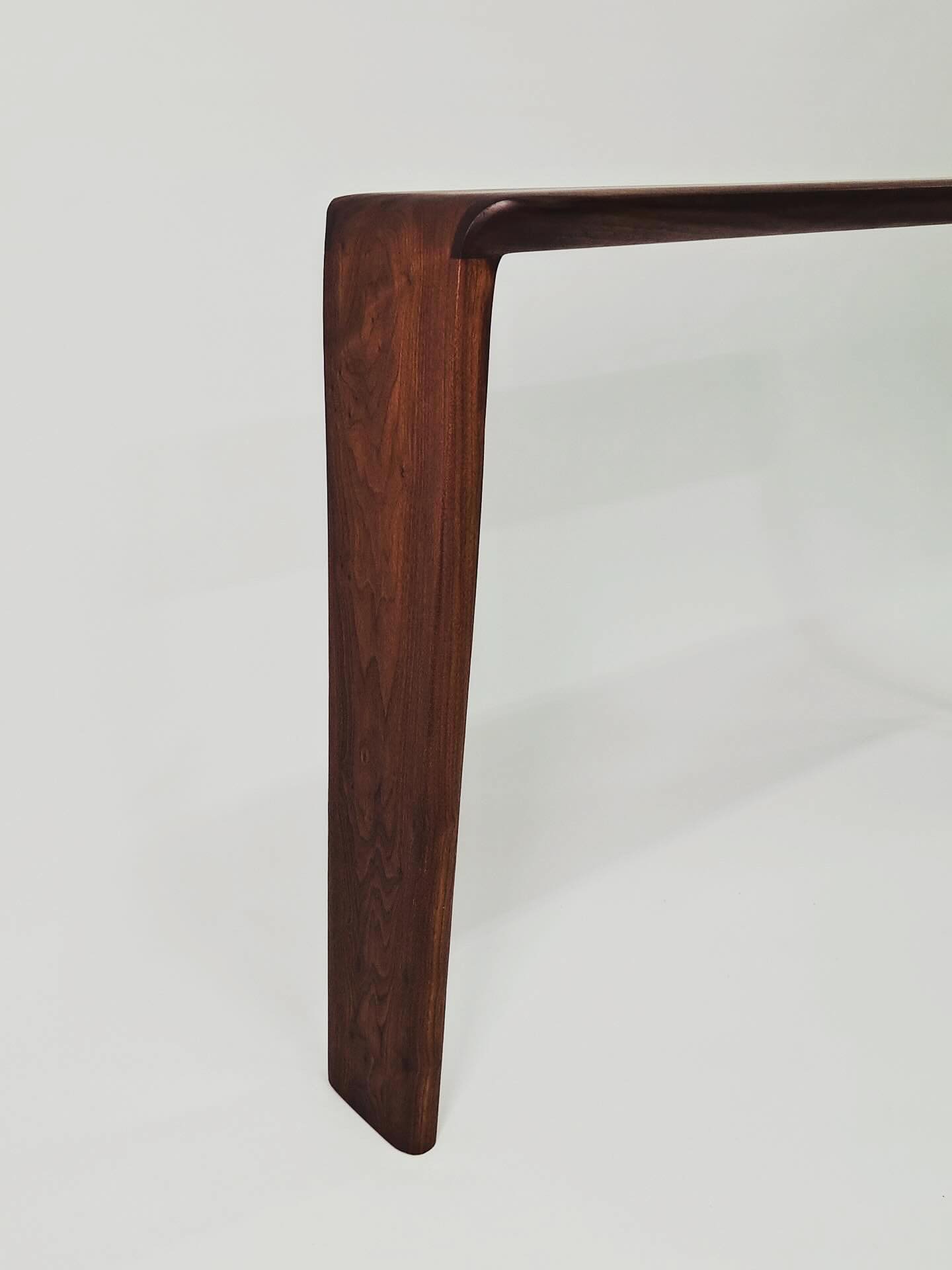 One leg of the console against a grey ground, tapering gently toward the floor