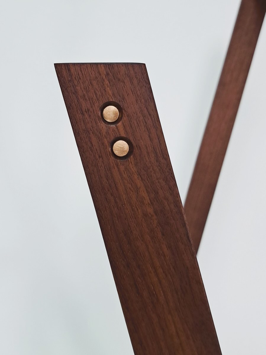 Close-up of a leg end with two brass pins seated in countersunk holes